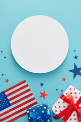 Obraz premium Happy Independence Day of America concept. Top view flat lay of gift boxes in national colors, national flag, blue, red, white stars on light blue background with blank circle for text or advert