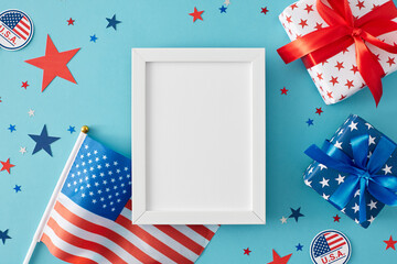 Celebration concept for America's Fourth of July holiday. Top view flat lay of gift boxes, american flag and stars in national colors on pastel blue background with frame for text or advert