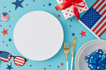 Obraz premium July 4th table decoration concept. Top view flat lay of plates, cutlery, gift boxes, american flag, patriotic decorations, stars on light blue background with blank circle for text or advert