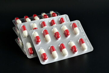 Red and white hard gelatin capsule in blister pack.