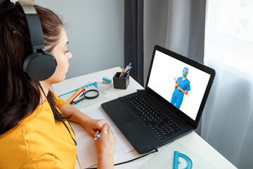 A girl makes a videocall with her doctor from home. The concept of online medicine, new...