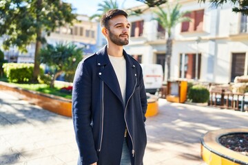 Young hispanic man smiling confident looking to the side at park