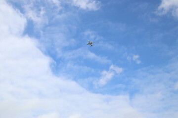 passenger airplane is flying in the blue sky with white clouds