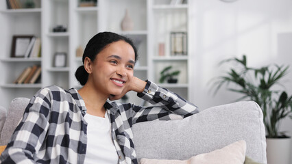 Fototapeta premium Carefree attractive young African American woman relaxing on sof