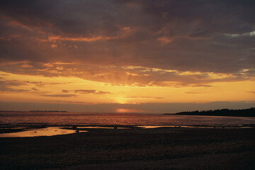 sunset above horizon over the sea. Beautiful cloudy evening sky. Abstract photo