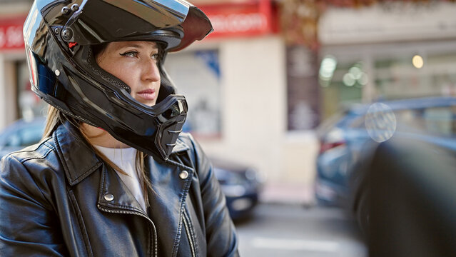 Young blonde woman wearing motorcycle helmet at street