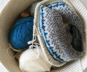 Fair Isle knitting in progress, alpaca grey white turquoise yarn balls in a basket