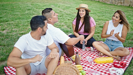 Group of people playing guitar having picnic at park