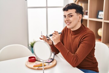 Young non binary man smiling confident applying makeup at home