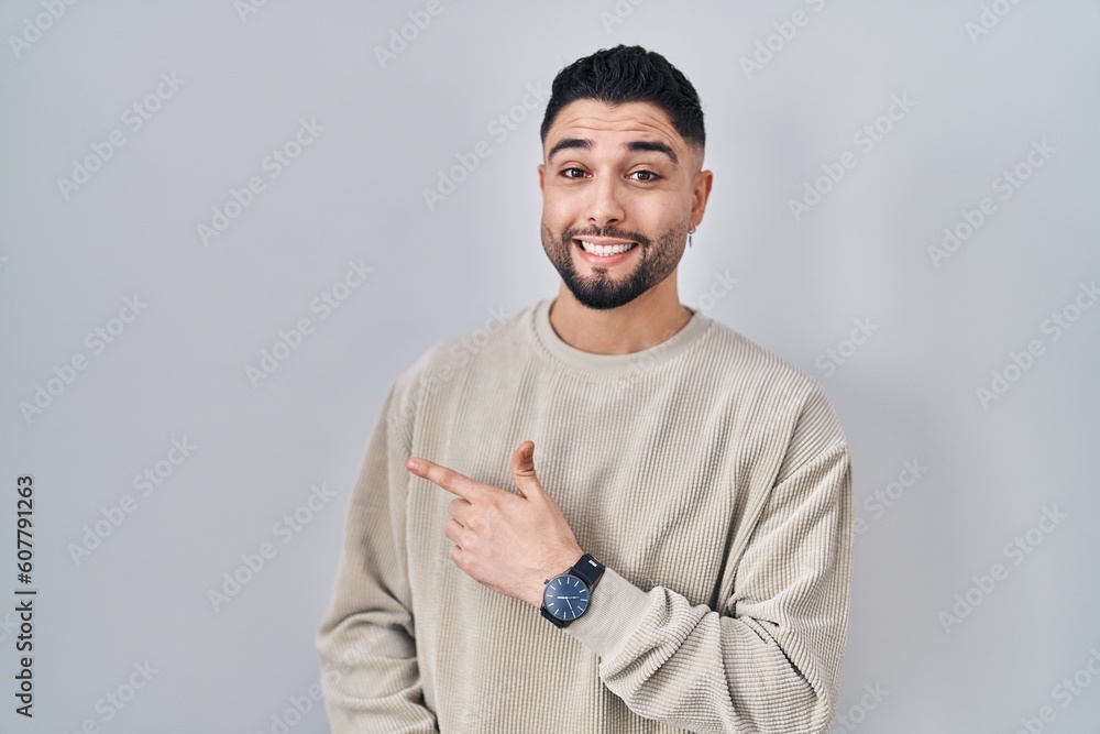 Canvas Prints Young handsome man standing over isolated background pointing aside worried and nervous with forefinger, concerned and surprised expression