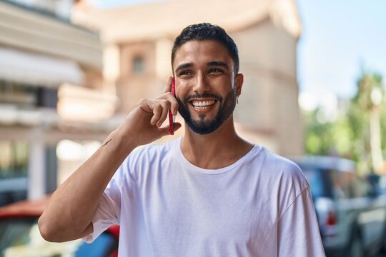 Young arab man smiling confident talking on the smartphone at street