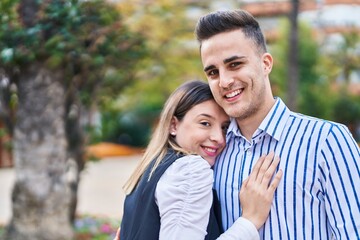 Fototapeta premium Man and woman couple smiling confident hugging each other at park