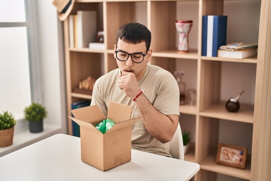 Young arab man with open gift in cardboard box feeling unwell and coughing as symptom for cold or bronchitis. health care concept.