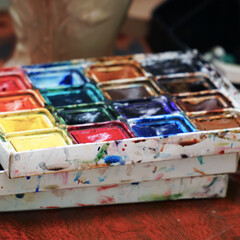Watercolor paints on the table. Selective focus