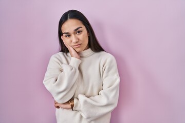 Young south asian woman standing over pink background thinking looking tired and bored with depression problems with crossed arms.