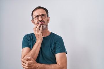 Middle age man standing with doubt expression over isolated white background