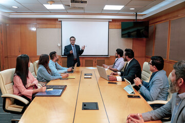 Indian business coach giving training to employees group at meting hall