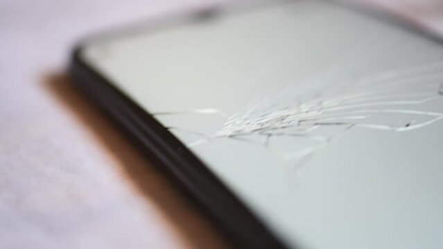 Vista cercana de una pantalla de tel&eacute;fono m&oacute;vil rota. Pantalla con varios rayones por ca&iacute;da del tel&eacute;fono.