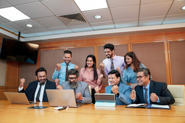 Fototapeta na wymiar Indian businesspeople group celebrate after dealing feel happy and signing contract or agreement at meeting room