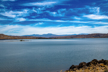 Fototapeta premium Experience the awe-inspiring beauty of Embalse Piedra de ?guila, where the tranquil reservoir harmonizes with the dramatic landscapes of Argentina