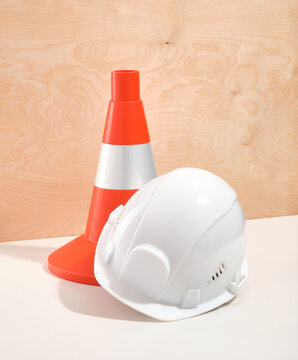Bright orange construction cone and white construction helmet for protect. Construction and hard work.