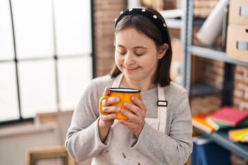 Young woman with down syndrome artist smiling confident drinking pencils at art studio