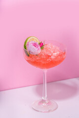 Frozen rose daiquiri or margarita cocktail, champagne, pink rose wine alcohol drink with roses flowers and lime slices