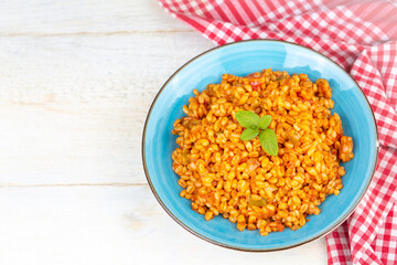 Traditional turkish bulgur pilaf with tomato sause in plate (Turkish name; meyhane pilavi)