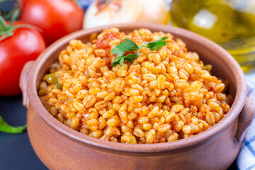 Traditional turkish bulgur pilaf with tomato sause in plate (Turkish name; meyhane pilavi)