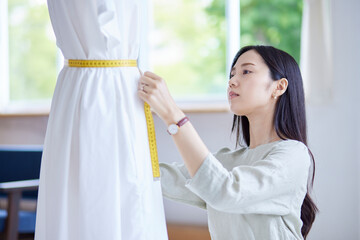 真剣に働く20代の日本人女性ファッションデザイナー