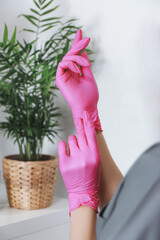 Wear rubber pink glove on hand on white background.