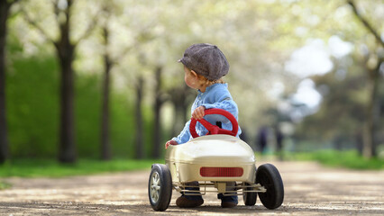 kleines Kind im retro Blechauto im Park