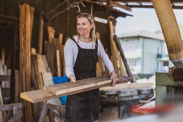 Woman working with wooden planks in a sawmill
