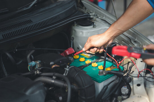 Professional mechanic checking customer's car's electrical system brought in for repair, all types of auto specialists, expert car repairs and certified auto repair centers.