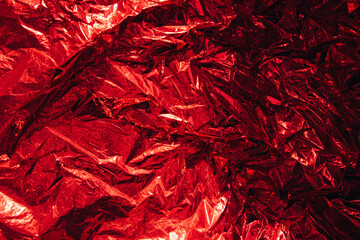 Abstract blurred crumpled foil red background, backdrop. Empty space for design