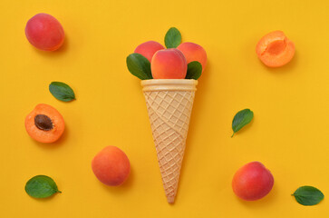 colorful food background ripe apricots with leaves on yellow background