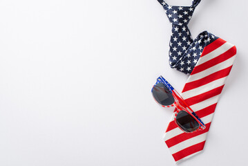 Obraz premium Festive Fourth of July display featuring party essentials: top view of party eyeglases and necktie with U.S. flag pattern on a white background with space for text or promotion