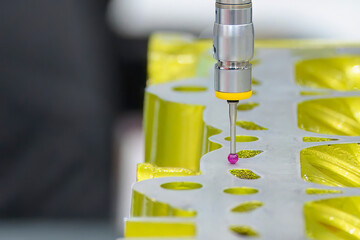 The CMM machine measuring the aluminum cylinder head parts .