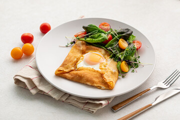 Portion of gourmet breakfast with fried egg in a pancake 