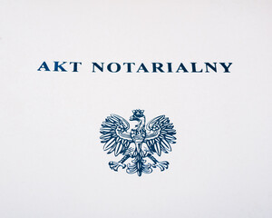 Zbliżenie na napis na teczce" akt notarialny" oraz orzełka 