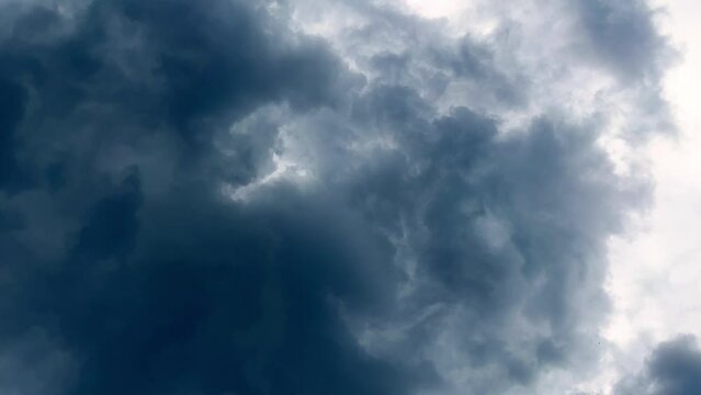 Dramatic time-lapse of moving white clouds in stormy sky. Timelapse of dynamic cloudscape in dramatic sky, vertical video