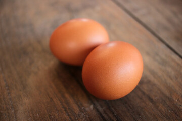 Close-up view of raw chicken eggs in egg basket on brown wooden background