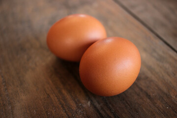 Close-up view of raw chicken eggs in egg basket on brown wooden background