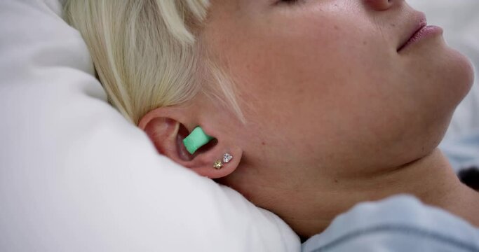 Woman Sleeping With Earplugs In Her Ears