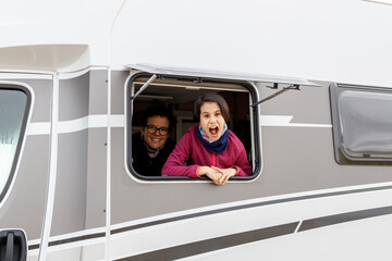 Mother and Daughter happy in a caravan window on the road in Iceland
