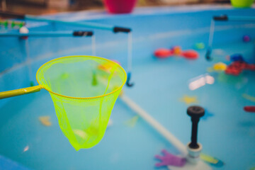 fishing in the paddling pool. Children's toys in the pool. Toy fish fishing rod. Cheerful children...