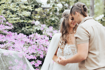 Emotional pregnant couple in blossom garden. Future parents in blooming rhododendron park.