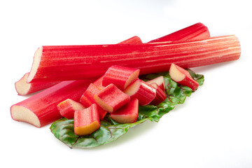 Red rhubarb stems' cuts over rhubarb leaves isolated on white background.