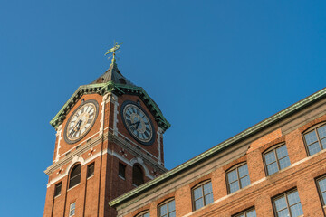 Fototapeta na wymiar Iconic clock tower and nineteenth century brick mill building in the historic immigrant city of Lawrence Massachusetts.