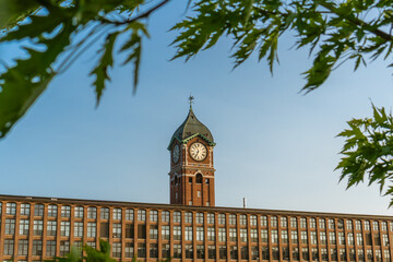 Iconic clock tower and nineteenth century brick mill building in the historic immigrant city of...